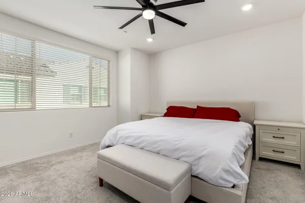 a bedroom with a bed and a ceiling fan