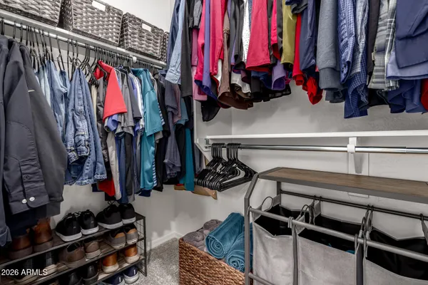 a view of walk in closet with clothes and shoes