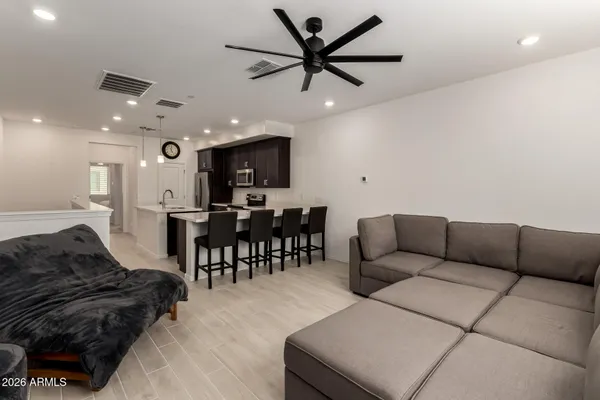 a living room with furniture and a dining table with kitchen view