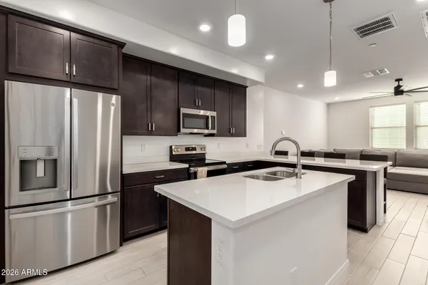 a kitchen that has a sink a stove and stainless steel appliances