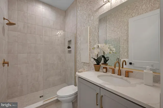 a bathroom with a sink a toilet and shower