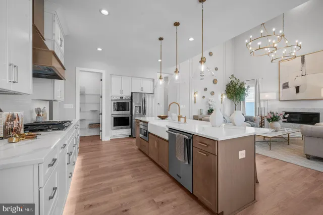 a large kitchen with kitchen island a sink a counter top space stainless steel appliances and cabinets