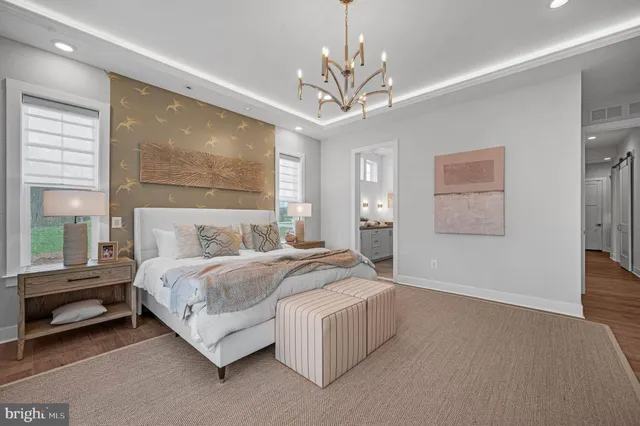 a spacious bedroom with a bed and a chandelier