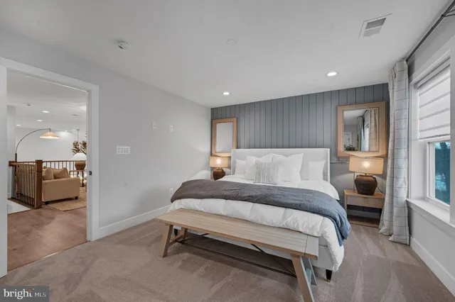 a spacious bedroom with a bed and a view of kitchen