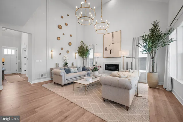 a living room with furniture a fireplace and a chandelier