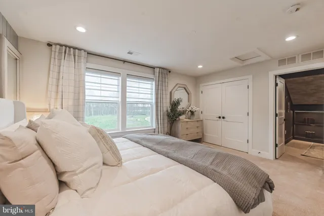 a spacious bedroom with a large bed and a large window