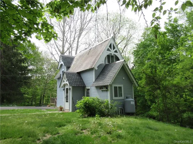 a front view of a house with a yard and trees