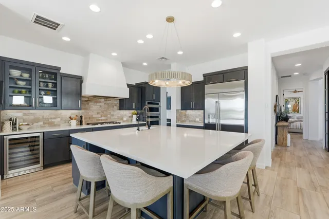 a view of a dining room with furniture one side kitchen view and wooden floor
