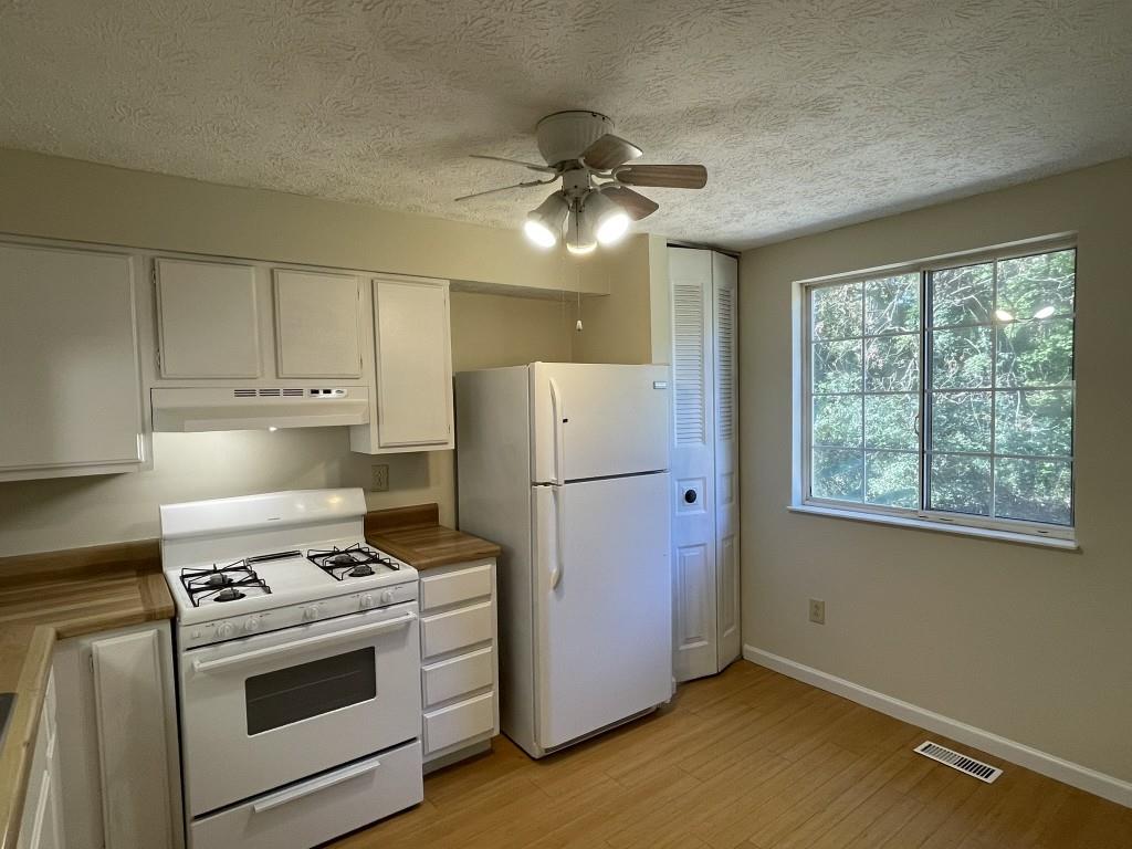 110 Roswell Commons Way Roswell, GA 30076 - Photo 24 of 26 a kitchen with a stove and a refrigerator