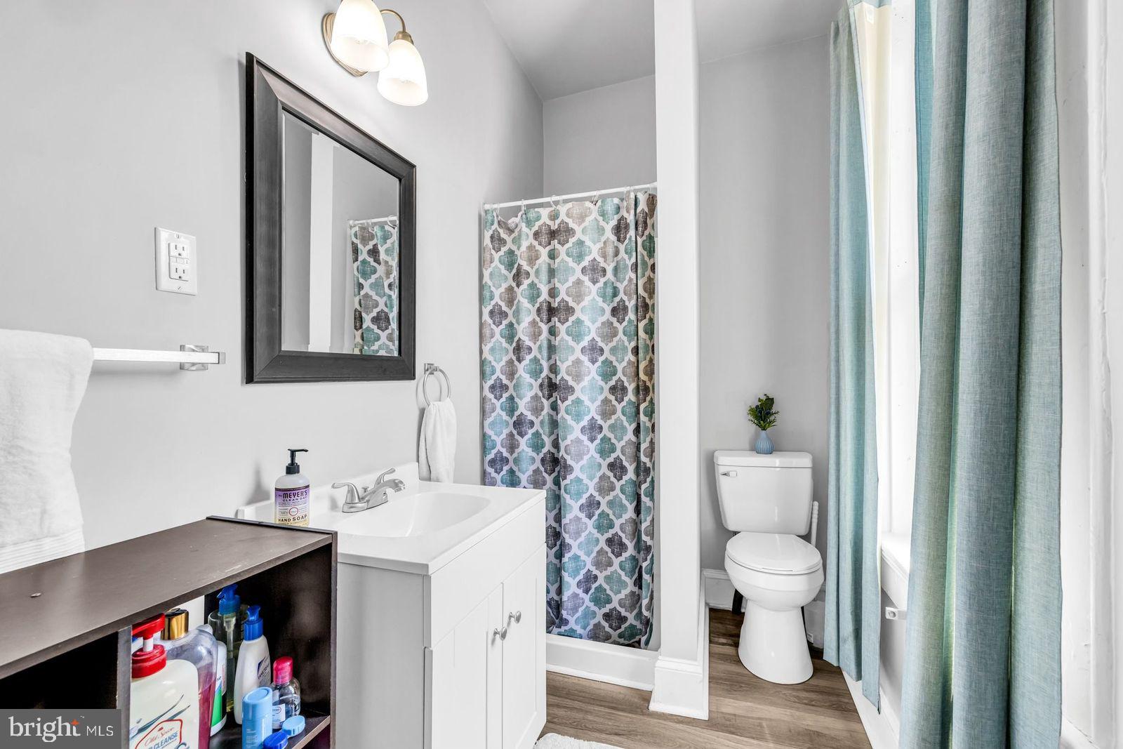 406 High Street Cambridge, MD 21613 - Photo 10 of 24 a bathroom with a sink a toilet and a large mirror