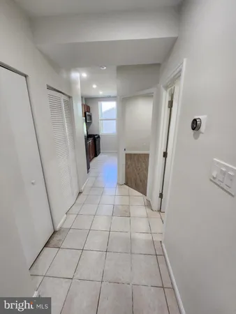 a view of a hallway to room with wooden floor