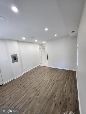 an empty room with wooden floor and entrance