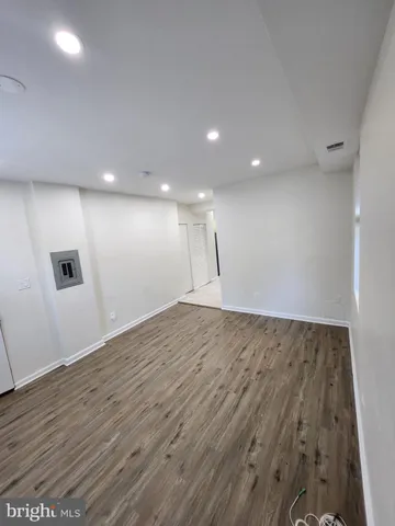 an empty room with wooden floor and entrance