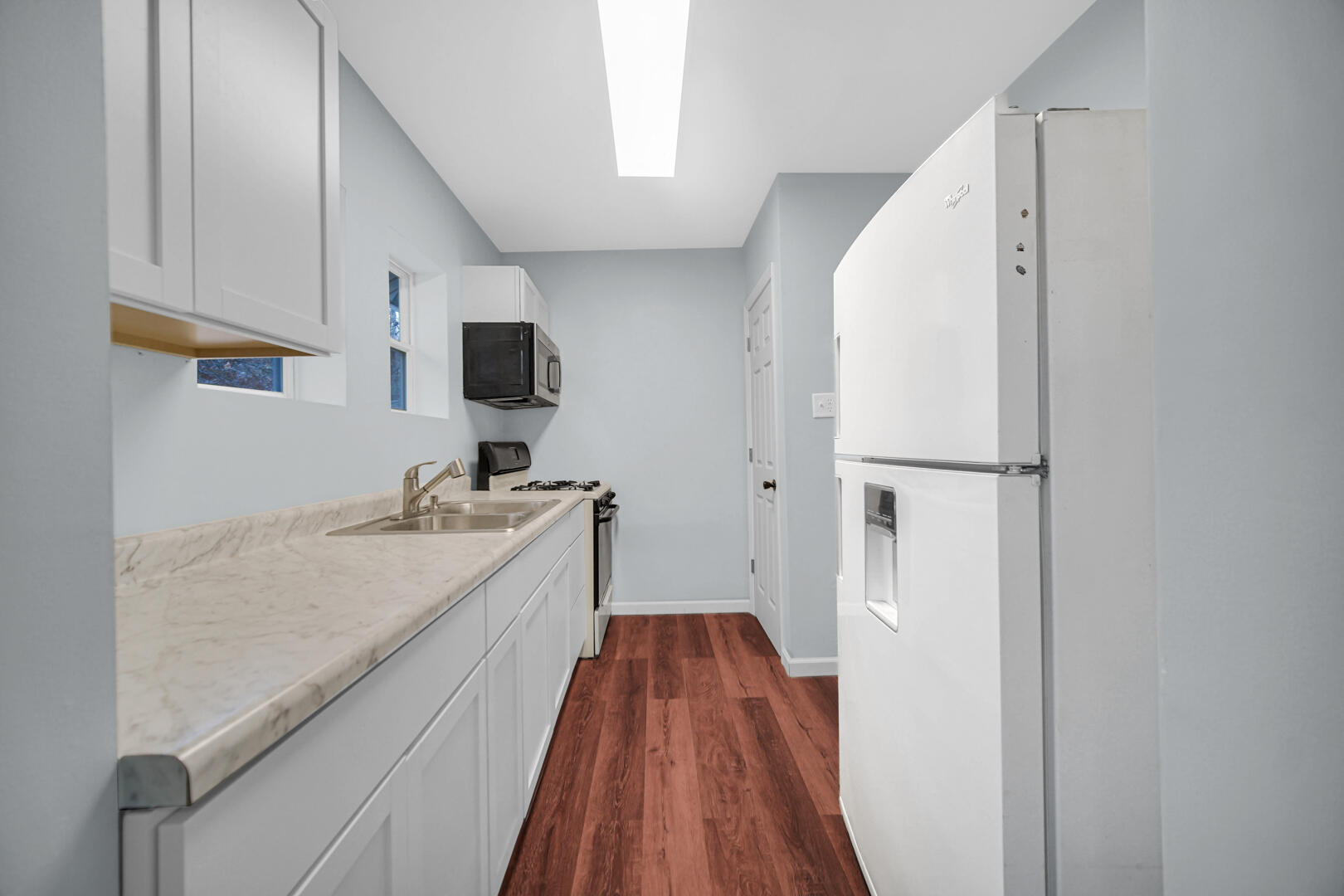 523 West 3rd Street Hobart, IN 46342 - Photo 12 of 17 a view of a kitchen with a sink and wooden floor