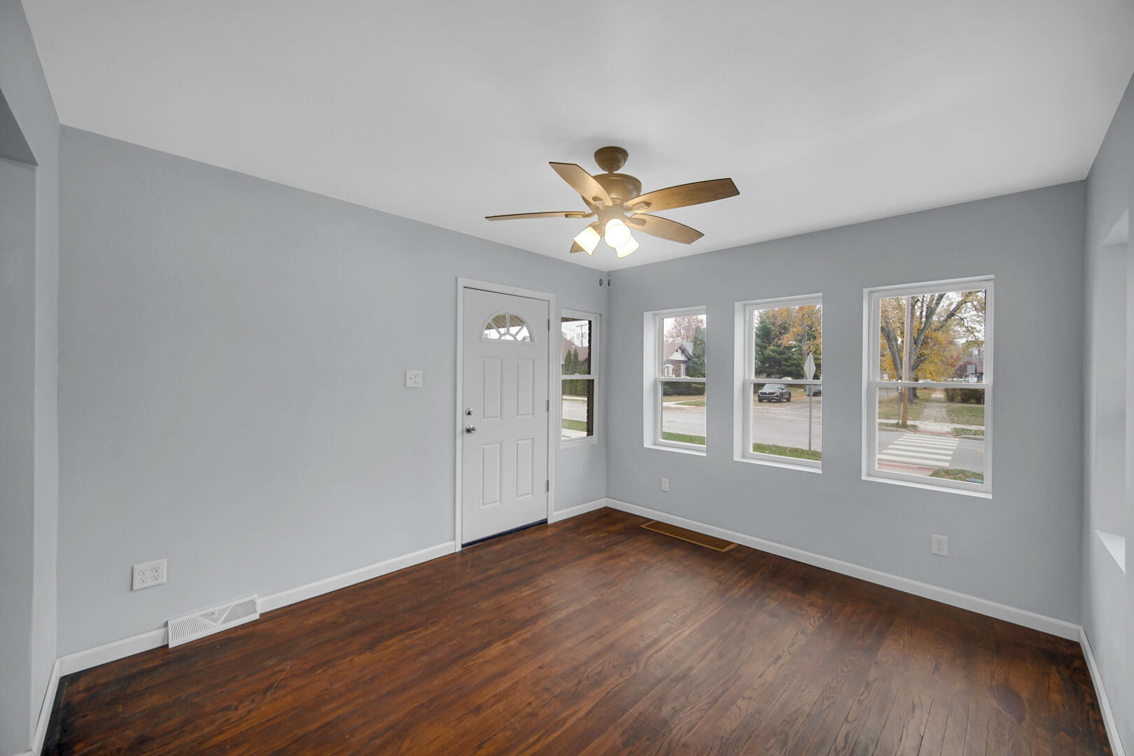 523 West 3rd Street Hobart, IN 46342 - Photo 5 of 17 a view of an empty room with a window and wooden floor