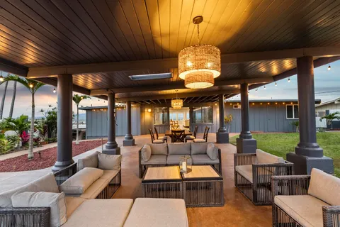 a view of a patio with couches and table and chairs with wooden floor and fence