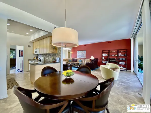 a view of a dining room and livingroom with furniture wooden floor a chandelier