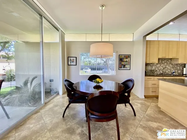 a view of a dining room and livingroom with furniture wooden floor a chandelier