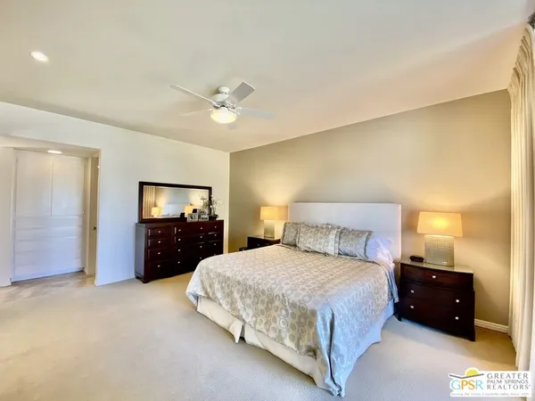 a spacious bedroom with a bed and dresser