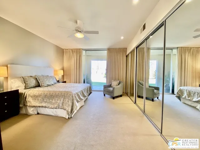 a spacious bedroom with a bed and glass door