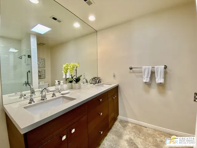 a bathroom with a sink double vanity and a mirror
