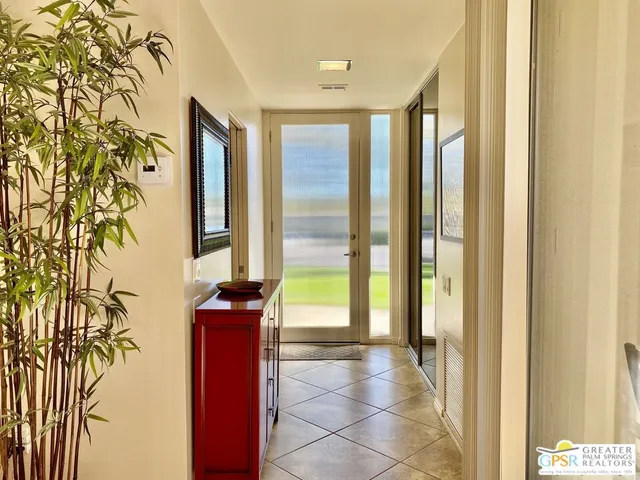 a view of a hallway with wooden floor and a dining room