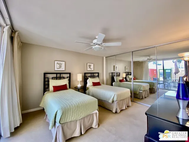 a bedroom with two beds and a chandelier