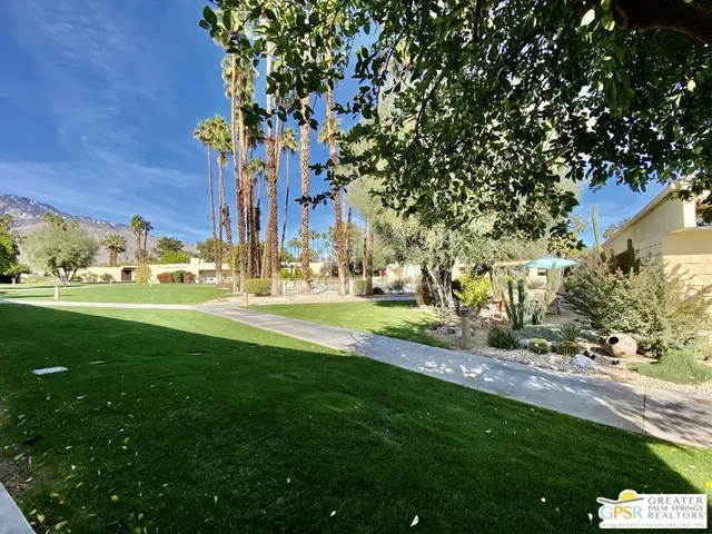 a view of a fountain in front of a house with a big yard