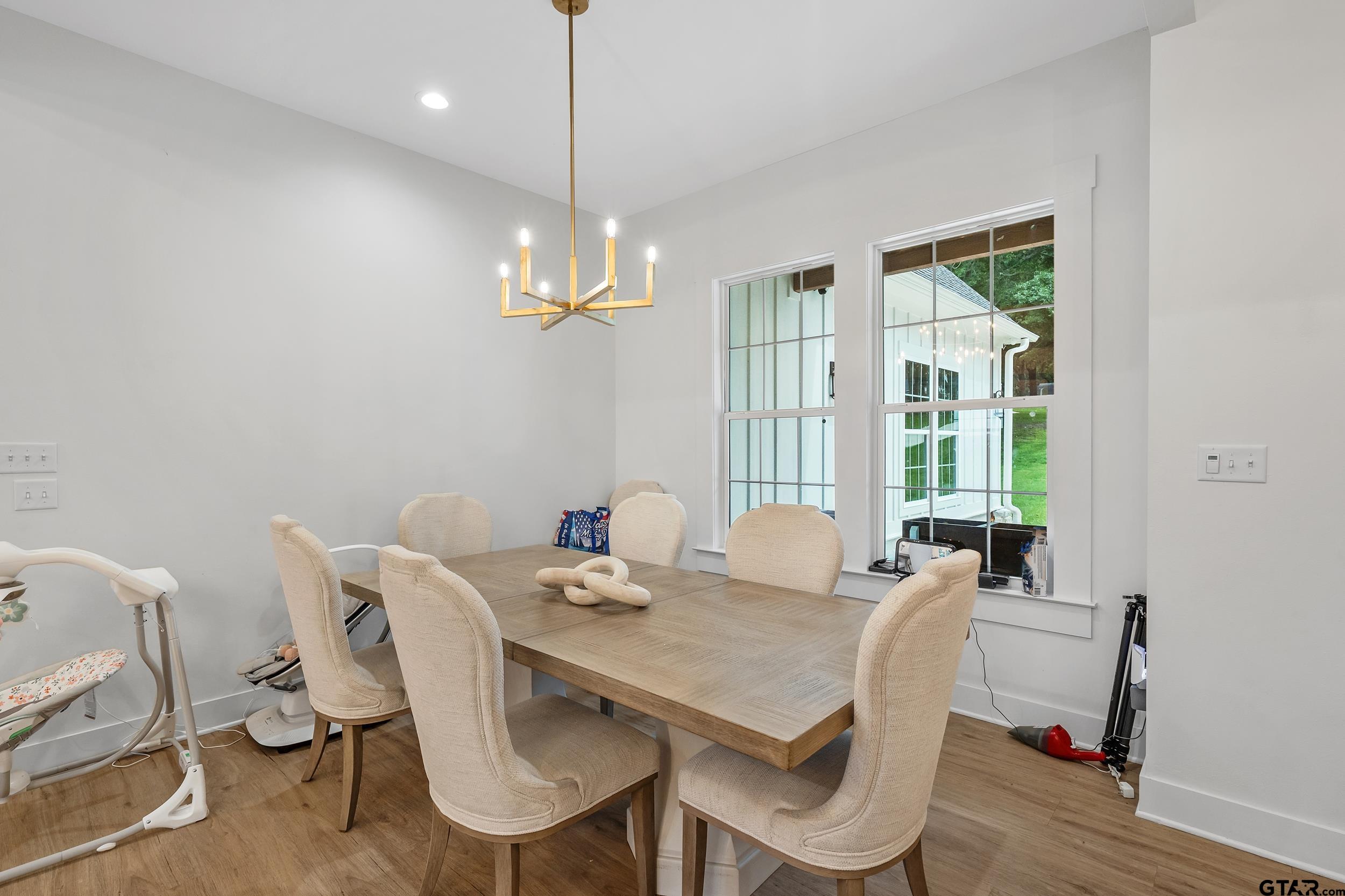 16837 Wilson Road Tyler, TX 75707 - Photo 14 of 44 a view of a dining room with furniture wooden floor and chandelier