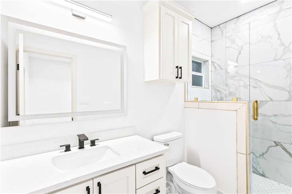 6801 South Azul Lane Pharr, TX 78577 - Photo 11 of 19 a bathroom with a sink a toilet a mirror and shower