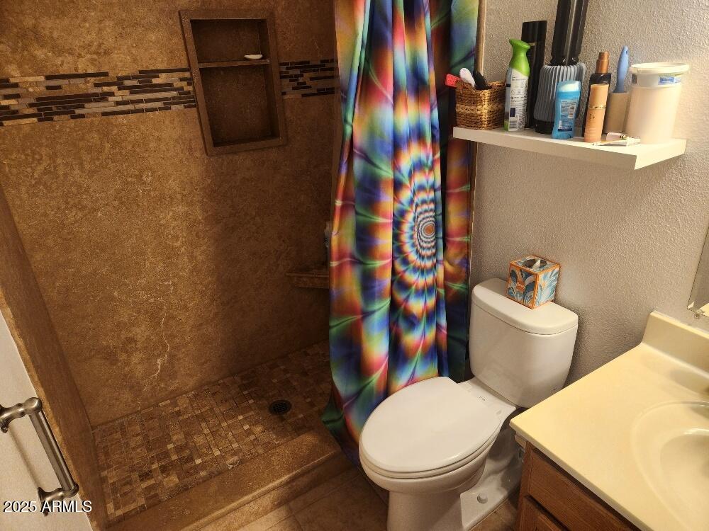 3511 East Baseline Road, Unit 1259 Phoenix, AZ 85042 - Photo 7 of 14 a white toilet sitting next to a bathroom sink and a mirror