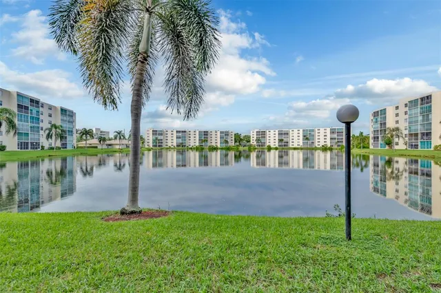 a view of a lake with a big yard and palm trees