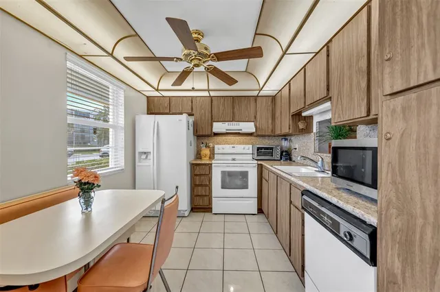 a kitchen with stainless steel appliances granite countertop a sink a stove and refrigerator
