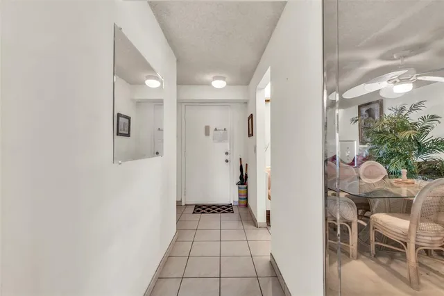 a view of a hallway to a livingroom and a dining room with furniture