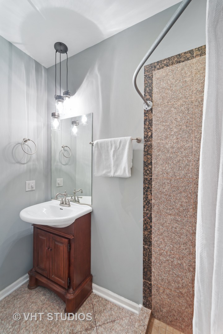 1733 South Ruble Street, Unit 1 Chicago, IL 60616 - Photo 11 of 19 a bathroom with a sink a mirror and a shower