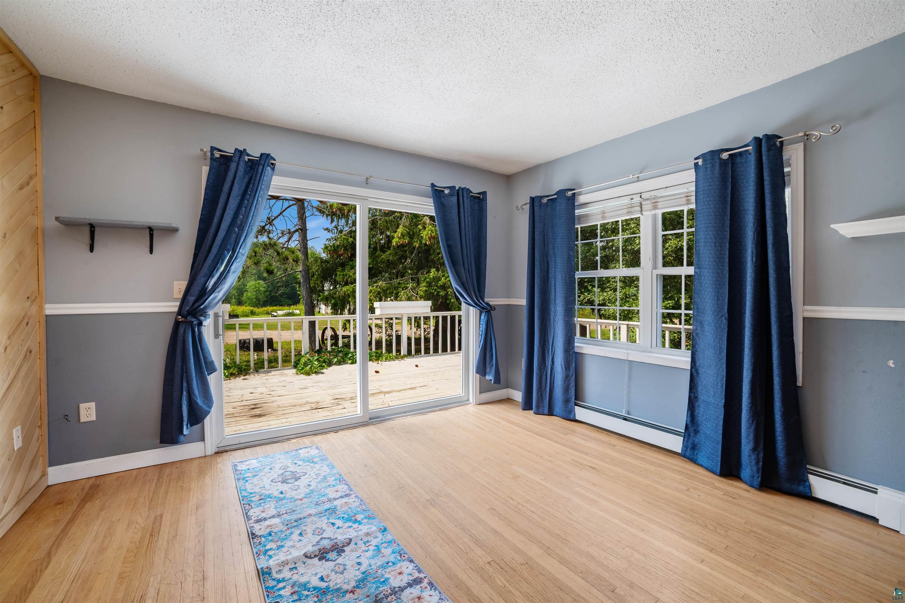 9372 McCamus Road Brookston, MN 55711 - Photo 19 of 49 Doorway to outside featuring a textured ceiling, wood finished floors, and a baseboard heating unit