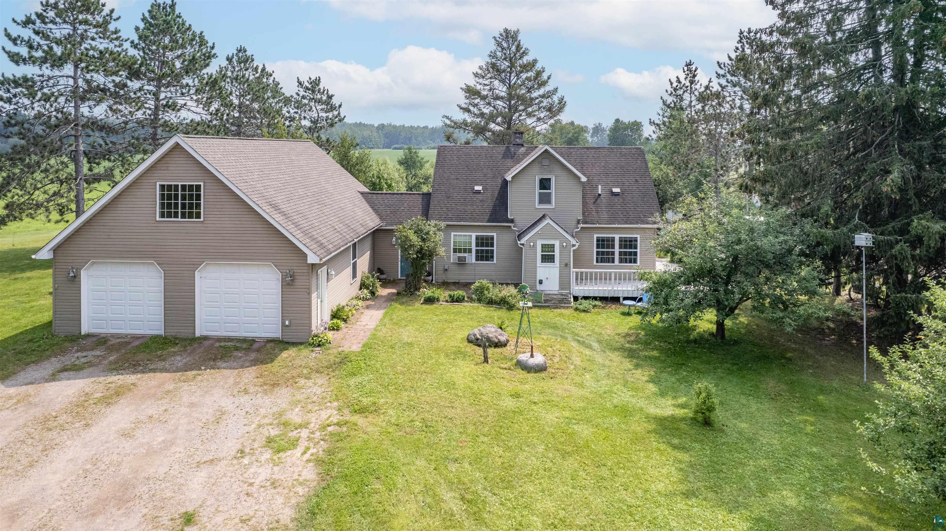 9372 McCamus Road Brookston, MN 55711 - Photo 2 of 49 Cape cod home featuring dirt driveway, a garage, a front yard, and a shingled roof