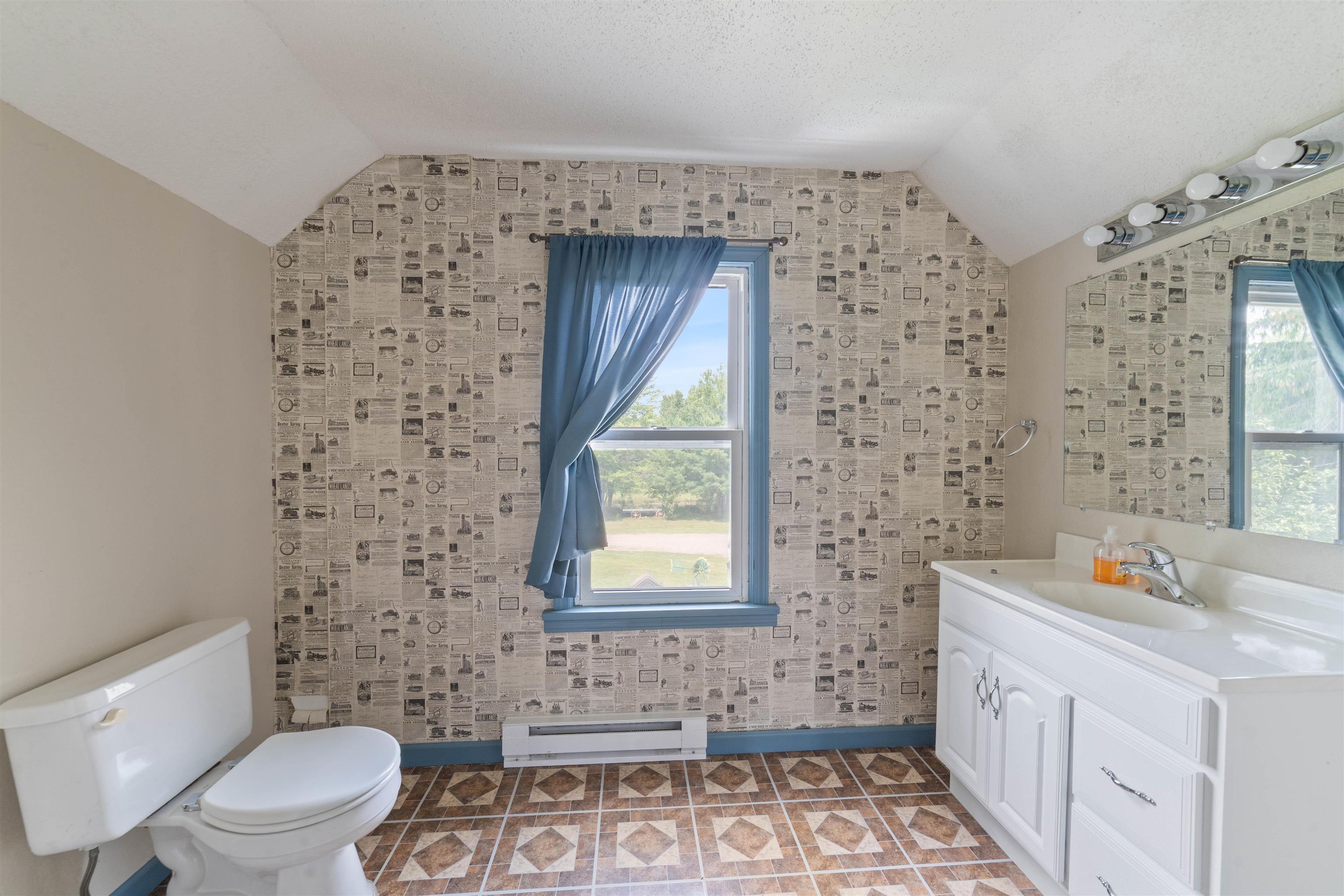 9372 McCamus Road Brookston, MN 55711 - Photo 31 of 49 Bathroom with a baseboard radiator, vanity, and lofted ceiling