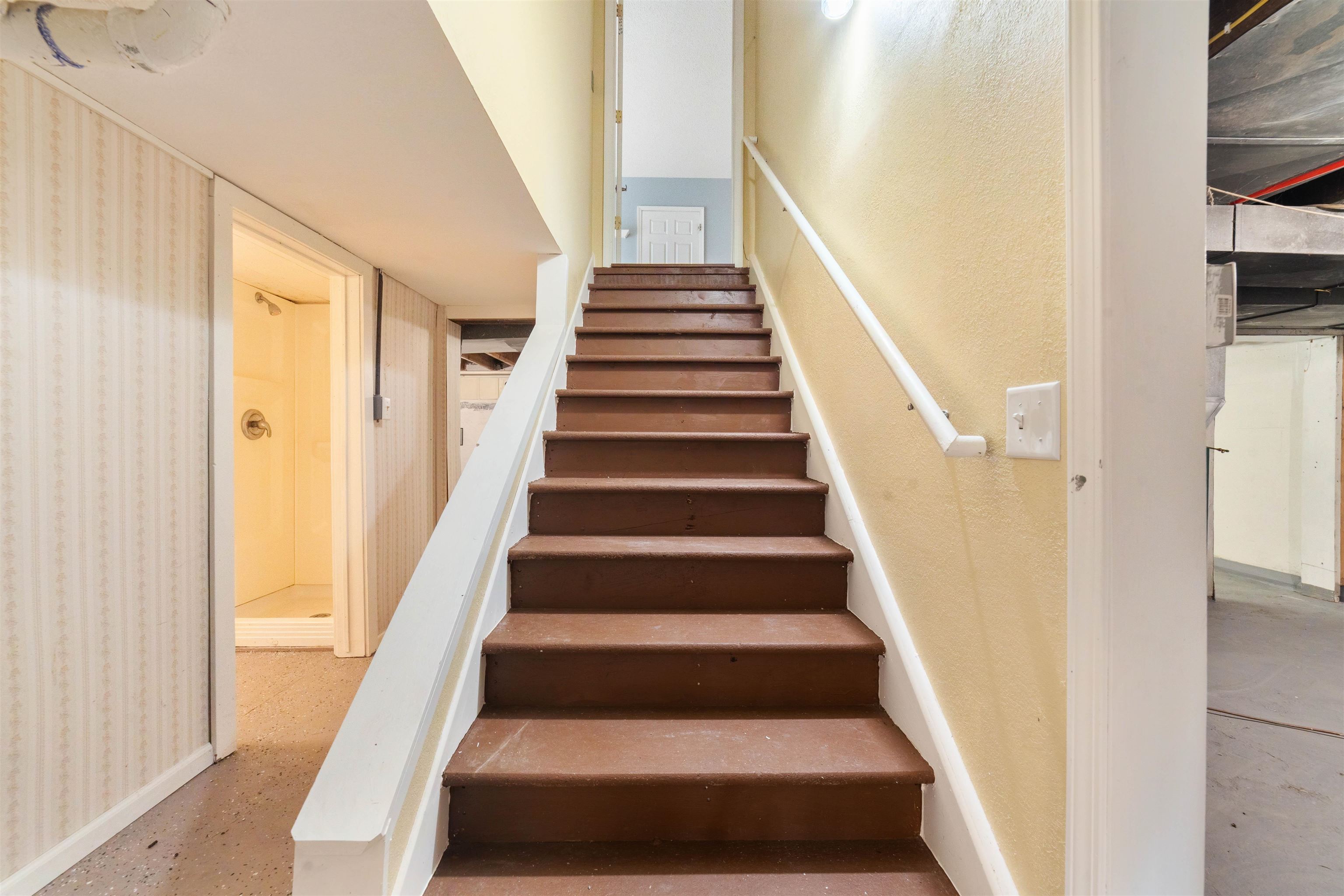 9372 McCamus Road Brookston, MN 55711 - Photo 35 of 49 Staircase featuring concrete floors and wallpapered walls