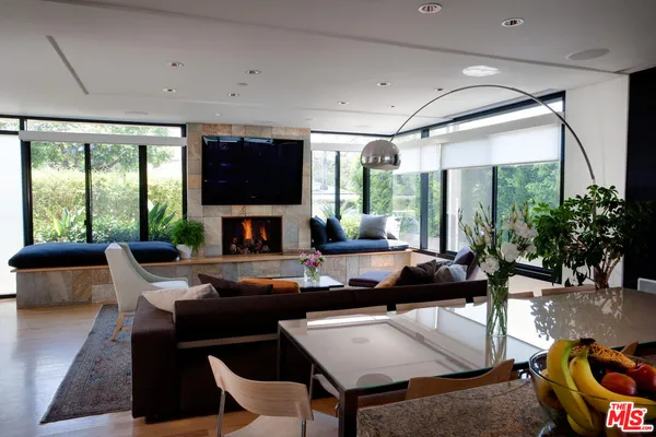 a living room with furniture a flat screen tv and a large window