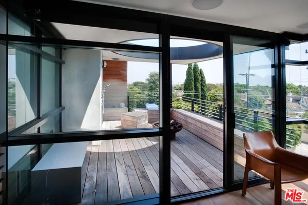 a view of a two room with wooden floor and furniture