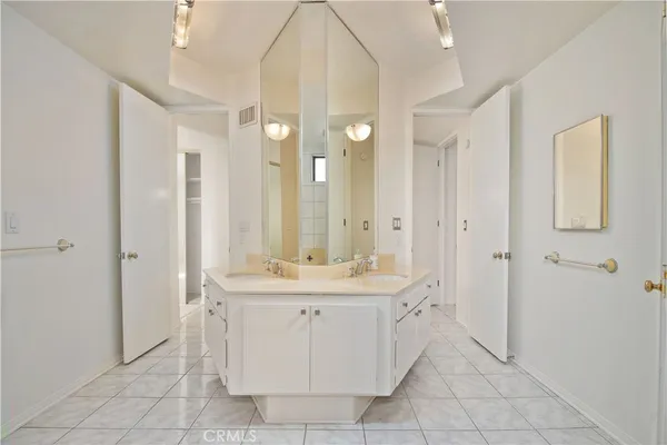 a bathroom with a double vanity sink a mirror and a bathtub