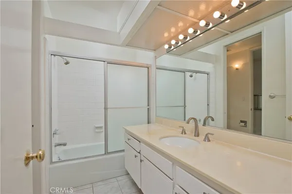 a bathroom with a sink shower and a mirror
