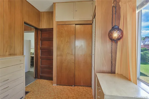 a bedroom with a bed and a potted plant on the dresser