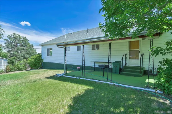 a backyard of a house with plants and outdoor seating