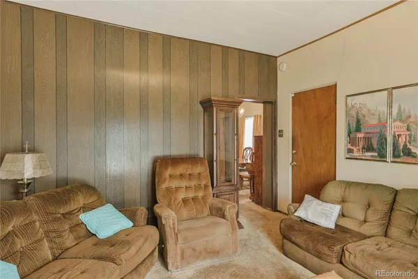 a living room with furniture and a painting on the wall