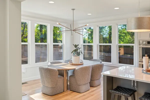 a dining room with furniture a chandelier and wooden floor