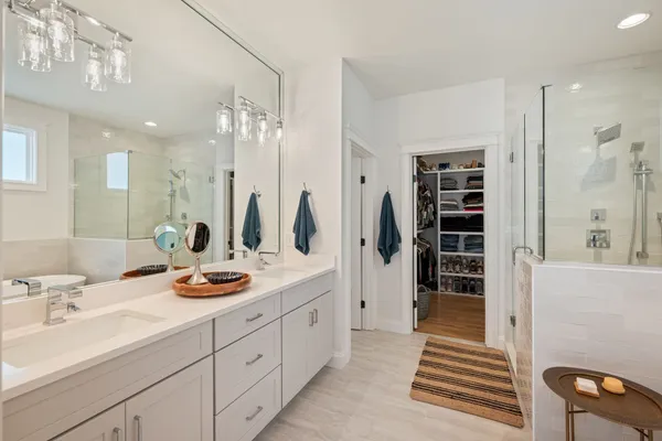 a bathroom with a double vanity sink a mirror and shower