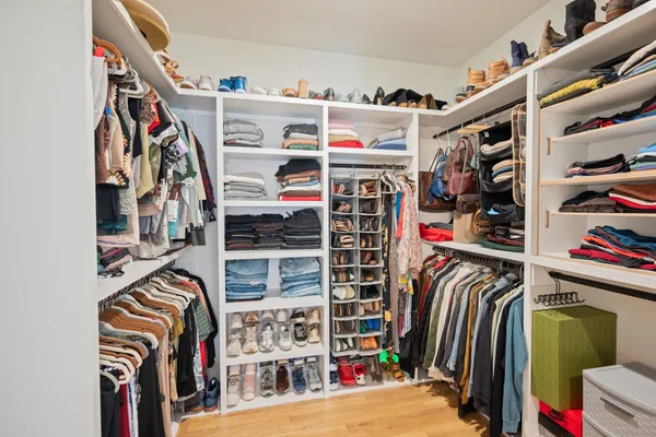 a view of walk in closet with clothes and shoes
