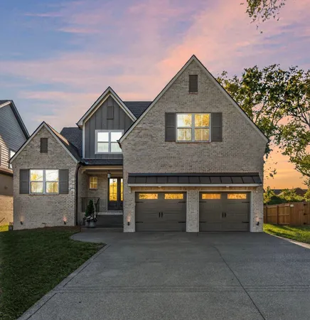 a front view of house with garage and trees